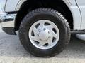 A close-up view of a silver wheel and tire of a 2013 Ford Econoline with a rugged tread pattern