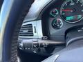 Close-up of the steering wheel and dashboard controls in a 2011 Chevrolet Avalanche showing gauges and control levers