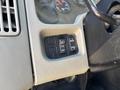 Dashboard controls of a 2011 International 4300 including buttons for headlights and panel illumination