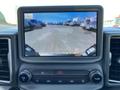 A dashboard display screen showing a rearview camera view from a 2023 Ford Bronco Sport with vehicles visible in the background