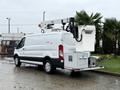 A white 2019 Ford Transit van equipped with a Versalift aerial lift mounted on the rear for maintenance tasks
