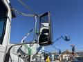 A side mirror of a 2020 Peterbilt 330 truck reflecting a clear blue sky