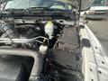 View of the engine compartment of a 2012 RAM 2500 showing the battery and various engine components with a coolant reservoir in the foreground