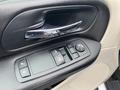 Close-up of the driver's side door control panel of a 2014 RAM Cargo Van featuring window and lock controls along with a mirror adjustment button