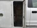 A 2018 Ford F-550 with an open side door revealing a spacious, empty storage compartment inside