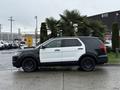 2019 Ford Explorer with a black and white color scheme parked on a surface with palm trees nearby and visible reflections on wet ground