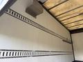 Interior view of a 2014 Hino 195 with metal track systems on the walls for cargo securing and hooks for storage