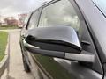 A close-up of the side mirror of a 2021 Toyota 4Runner featuring a sleek black design and a reflective surface