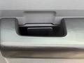 A close-up view of a textured black handle on the door of a 2011 Ford F-350 SD