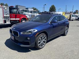 A 2018 BMW X2 parked in a lot featuring a blue exterior sleek design and distinctive kidney grille with sporty wheels