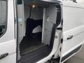 A 2017 Ford Transit Connect with an open sliding side door revealing a spacious cargo area and metal partition