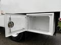 A 2020 International MV607 truck with an open side compartment showcasing a spacious interior and a locking mechanism
