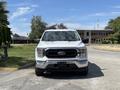 A 2021 Ford F-150 pickup truck facing forward with a white exterior and chrome accents