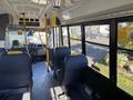 Interior view of a 2017 Ford Transit-350 showing seating arrangement with blue seats and a driver's area visible in the front