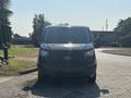 A black 2016 Ford Transit 150 van is facing the camera with its windshield and front grille prominently visible