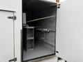 Interior view of a 2014 International TerraStar showing an empty storage space with a shelf and a horizontal pole along the wall