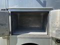 An open storage compartment of a 2008 Workhorse W62 with metal walls and a flat floor showing empty space inside