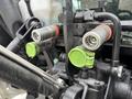 Close-up of hydraulic connections on a 2009 New Holland T4020 tractor featuring metal fittings with green and orange caps