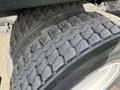 Close-up of the worn tires on a 2012 International DuraStar 4300 showing deep treads and signs of use