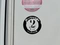 A round black sticker with white text reading Westland 2 Y & F Structural Warranty on a white surface
