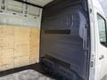 Interior of a 2022 Mercedes-Benz Sprinter showing a wooden panel on one side and a smooth grey interior wall