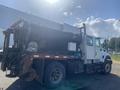 A 2014 International 7400 truck with a black cargo container and various equipment mounted on the side