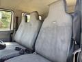 Interior view of a 2011 International 4300 featuring two gray upholstered seats with seatbelts