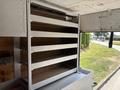A metal shelving unit with five horizontal shelves inside a vehicle's cargo area