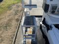 A white metal platform with a textured surface and a small step leading up to it designed for accessing equipment on a 2013 International 7500 truck