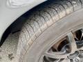 A close-up view of the tire and wheel of a classic 1968 Ford Mustang Two Door Convertible with a black alloy wheel and treaded tire