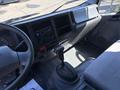Interior of a 2016 Isuzu NPR-HD showing the dashboard gear shift and control panel with radio and air conditioning controls