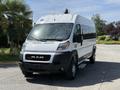 A 2021 RAM Promaster van in white with a black front grille parked on a pavement featuring sliding side doors and large tires