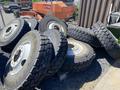 Set of 10 heavy duty tires stacked together showcasing rugged tread patterns and metallic rims