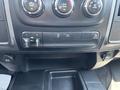 Interior dashboard controls of a 2013 RAM 2500 featuring climate control knobs and buttons for towing and auxiliary functions