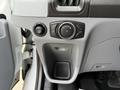 Control panel of a 2017 Ford Transit featuring knobs for lights and a cup holder section without any contents