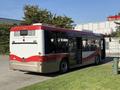 A 2016 Grande West Vicinity bus with a red and white color scheme parked with its rear facing the viewer