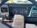 Dashboard of a 1996 GMC Top Kick showing gauges for speed and fuel along with control knobs and a GMC logo on the steering wheel
