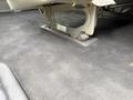 A 2004 Chevrolet Express seat base attached to the floor showcasing metal mounting and fabric upholstery