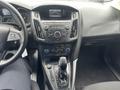 Interior view of a 2018 Ford Focus showing the steering wheel center console and gear shift with a display screen above the controls