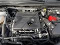 A 2020 Ford Escape engine with a black engine cover and visible components such as hoses wires and a red battery