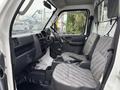 Interior of a 2008 Suzuki Carry showing front seats and dashboard with basic controls and gear shift in a compact design
