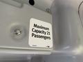 A label inside a vehicle stating "Maximum Capacity 21 Passengers" indicating the seating limit for the 2019 Chevrolet Express