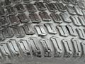 Close-up of a tire tread with deep grooves and a rugged surface designed for traction on various terrains