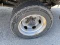 A close-up of a flat tire on a 2014 Hino 195 truck showing worn tread and a rusty wheel rim