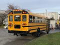 A yellow 2013 International 4300 school bus parked with its rear view visible showing the windows and lights