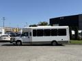A white 2020 Chevrolet Express with large windows designed for passenger transport parked on a concrete surface
