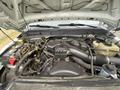 Engine compartment of a 2014 Ford F-350 SD showing various components including the air intake manifold battery and cooling system parts
