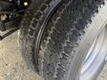 Close-up of the tread on two tires of a 2015 Ford F-550 showing worn rubber and deep grooves