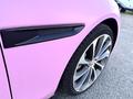 A pink 2020 Jaguar XE showing the front fender and alloy wheel with a close-up of the branding on the side vent