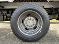 A close-up of a wheel and tire on a 2015 Ford F-550 featuring a silver rim and a rugged black tire with treads visible
